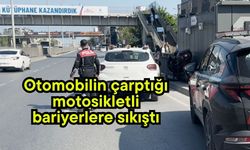 Otomobilin çarptığı motosikletli bariyerlere sıkıştı