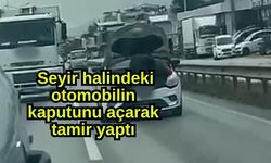 Seyir halindeki otomobilin kaputunu açarak tamir yaptı